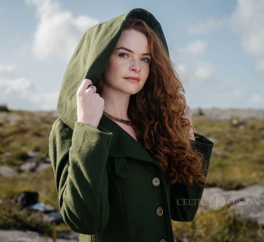Close-up of romantic green wool coat showing oversized hood, button front and tailored folklore-inspired fit