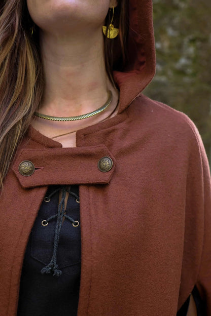 Close-up of rust hooded wool cloak showing neckline fastening, metal buttons and felted wool texture