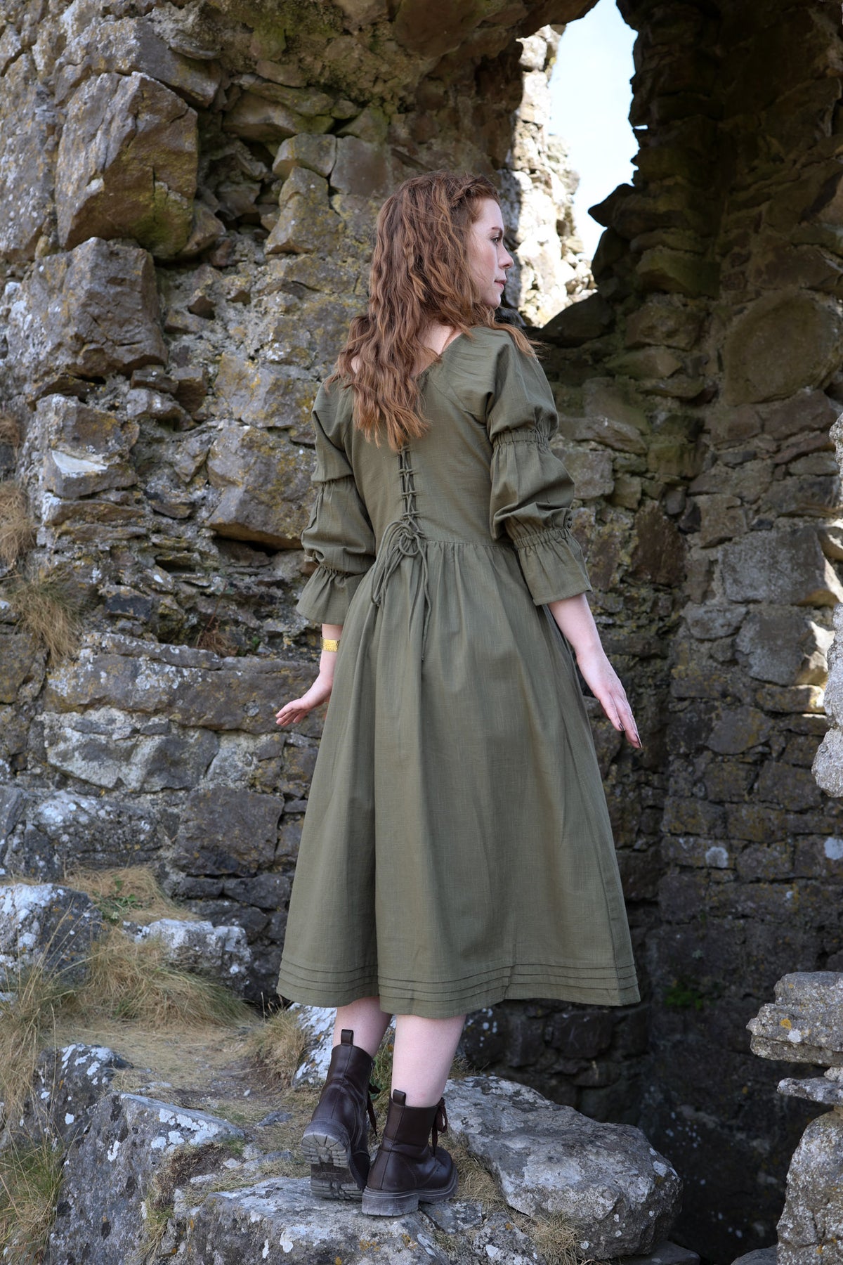 Fiadh sage green corset back midi dress showing the adjustable lace-up waist, gathered skirt and long sleeves